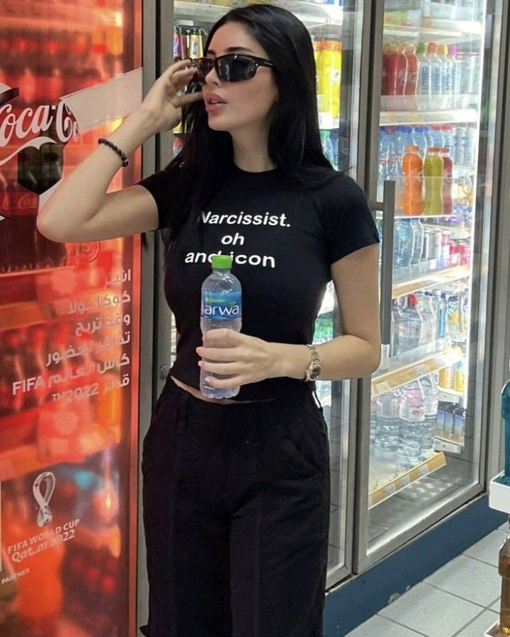 Kacamata hitam bentuk kotak yang dikenakan Liz memberi kesan fierce, classy, dan membangun batas yang elegan.