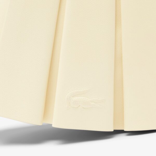 Detail desain khas Lacoste dengan logo buaya timbul dan tekstur bahan premium yang terinspirasi dari warisan tenis.